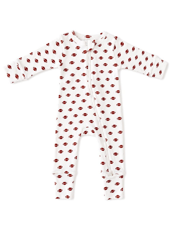 White baby onesie with red football patterns, featuring long sleeves and a front zipper closure.