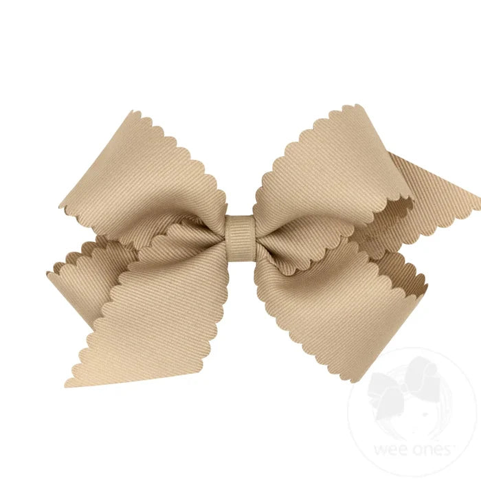 A brown grosgrain scalloped edge hair bow on a white background.