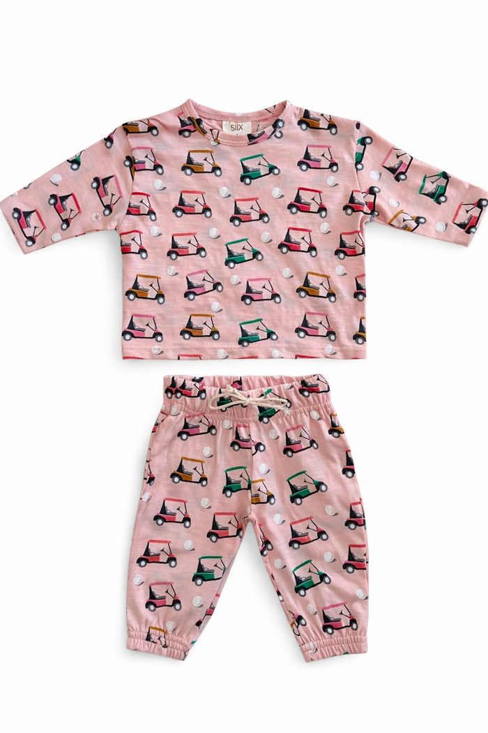 Pink children's outfit featuring a golf cart pattern, consisting of a top and matching pants.