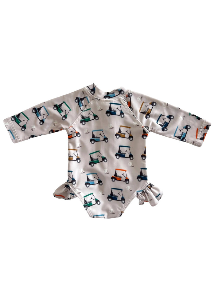 Child's long-sleeve swimsuit featuring colorful golf cart patterns on a white background.