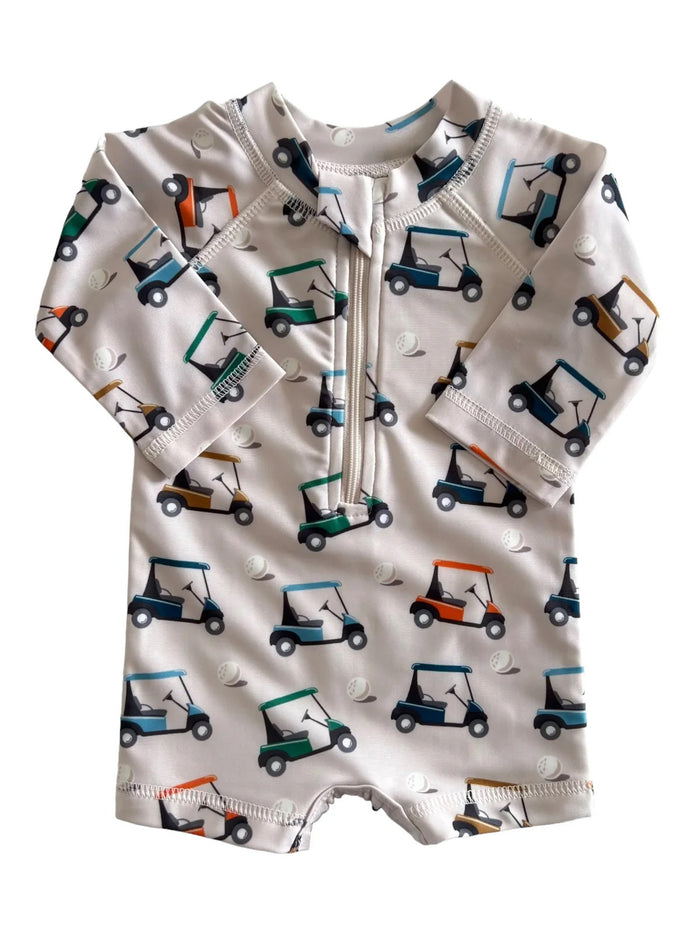 Kids' golf-themed rash guard with a zipper, featuring colorful golf carts on a light background.