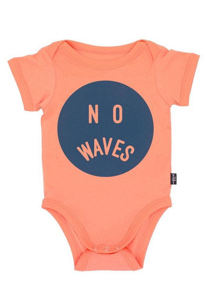 Coral baby onesie with circular design featuring the words "NO WAVES" in navy blue.