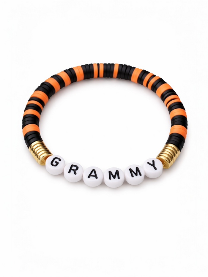 Colorful beaded bracelet featuring the word "GRAMMY" in white letters on a black and orange striped band.