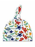 Colorful baby hat with a knot on top, featuring vibrant tropical patterns of plants and marine life.