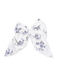 Floral patterned hair bow in white and blue fabric, tied in a large bow shape.