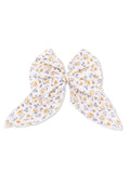 White floral hair bow with yellow and lavender flowers, tied in a large bow shape.