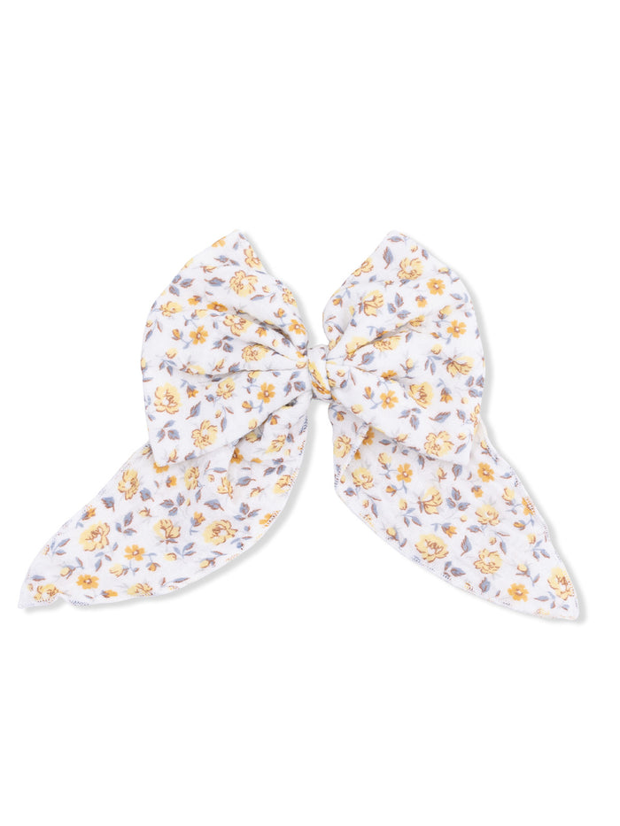 White floral hair bow with yellow and lavender flowers, tied in a large bow shape.