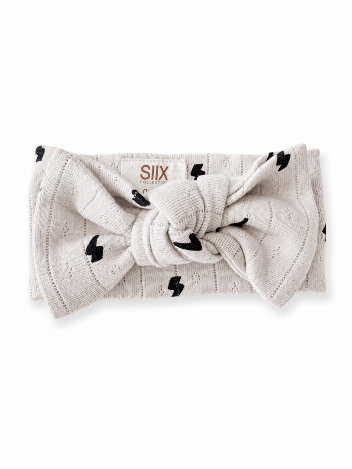 Light gray headband with black lightning bolt pattern and knot detail, branded with "SIIX COLLECTION" logo.