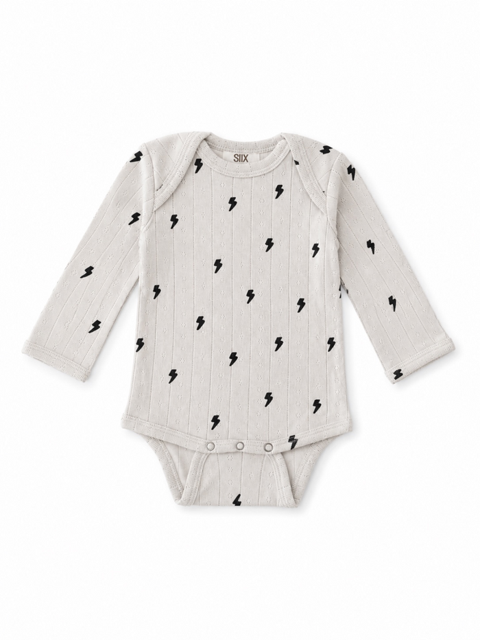 Gray long-sleeve baby onesie with black lightning bolt pattern and snap closure at the bottom.