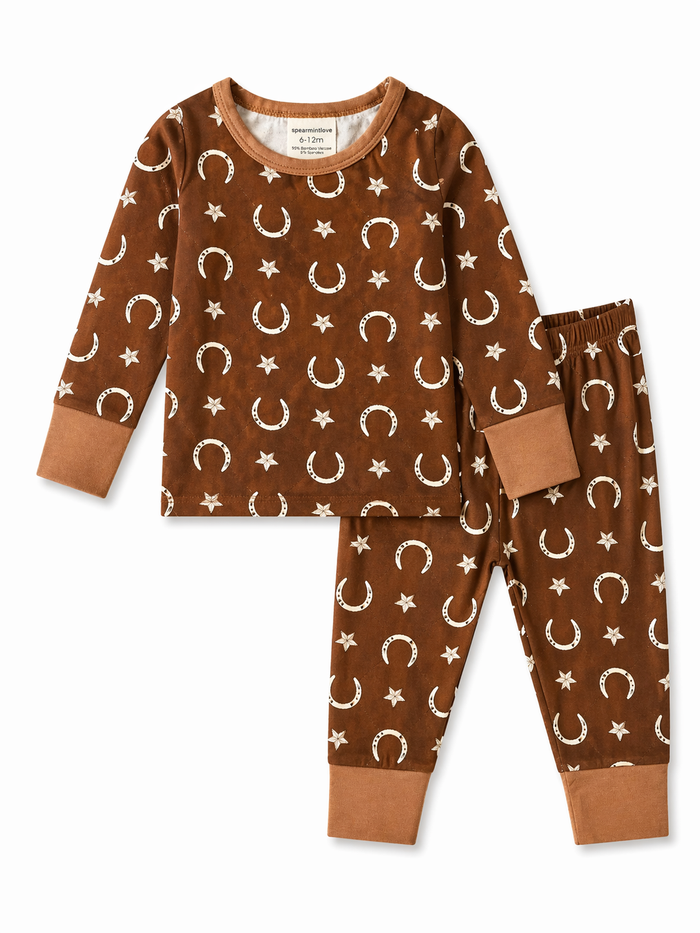 Brown children’s pajama set with white stars and crescent moon prints, featuring long sleeves and elastic pants.