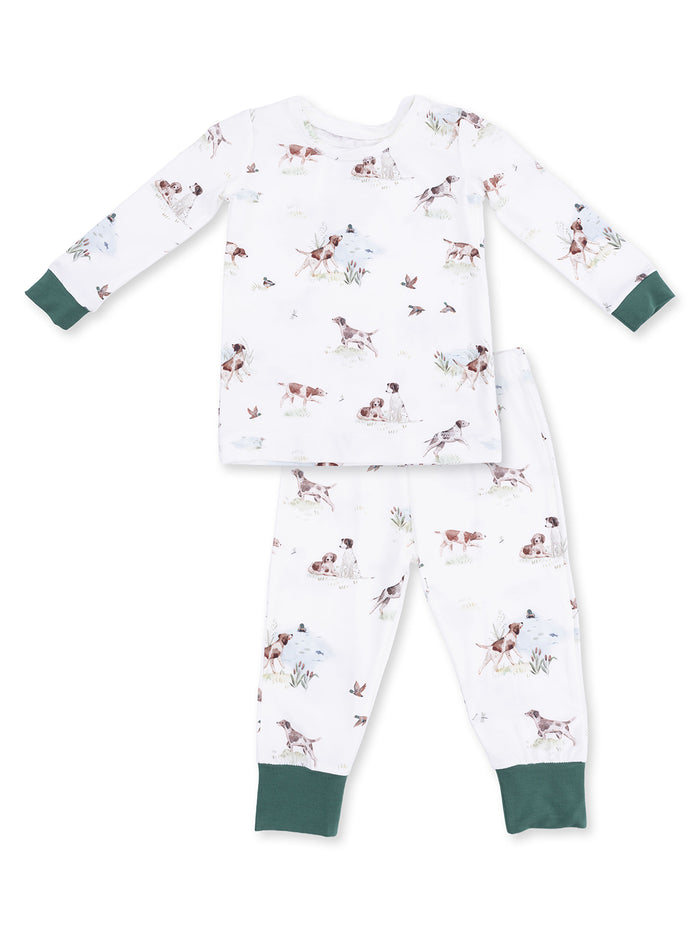 Kids' pajama set featuring playful dog and nature prints on a white background with green cuffs.