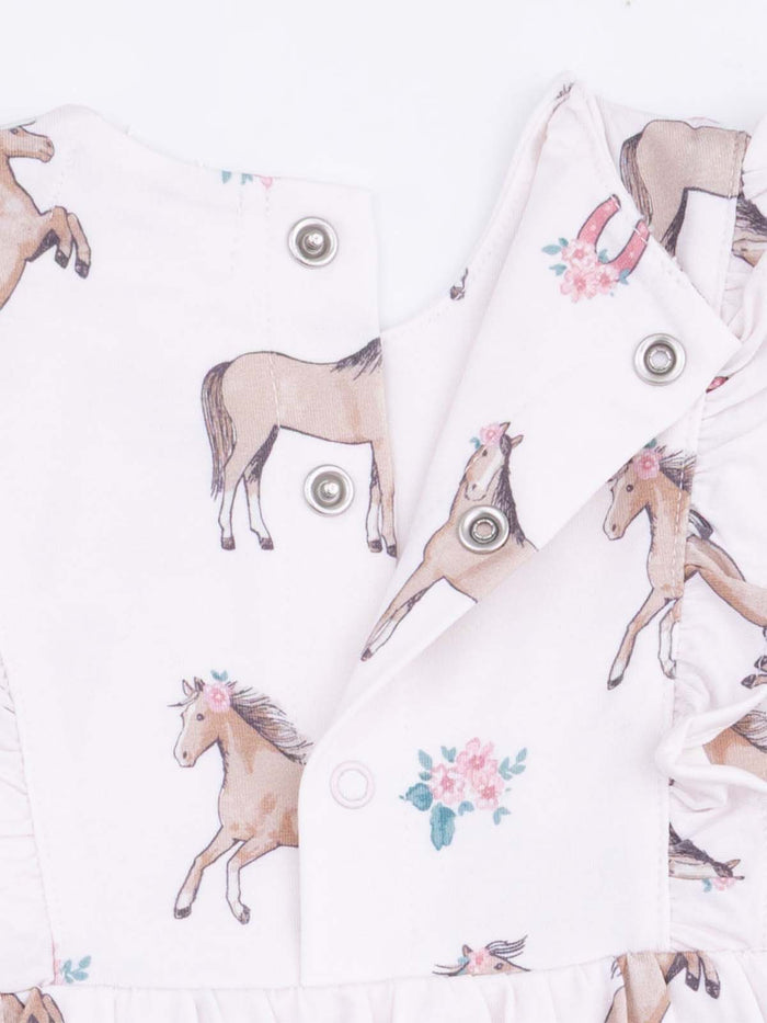 Pink dress with horse prints and floral accents, featuring snap buttons and a ruffled hem.