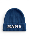Blue knitted beanie with a folded cuff featuring the word "MAMA" in white letters.