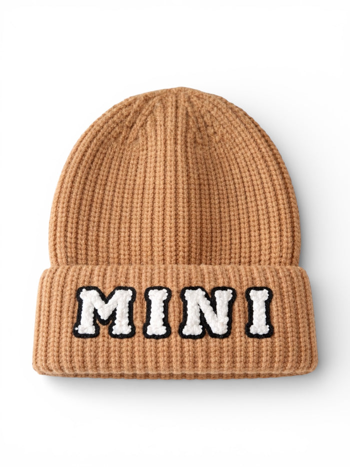 Brown knit beanie with a folded cuff featuring the word "MINI" in white and black letters.