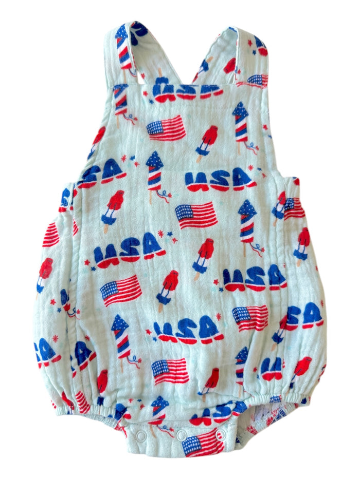 USA-themed baby romper with flags and fireworks design in red, white, and blue colors. Perfect for celebrations.