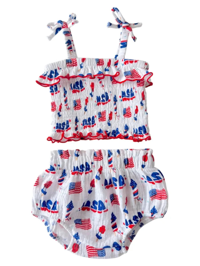 Baby girl's two-piece outfit featuring white fabric with red and blue patterns of flags and "NASA" print.