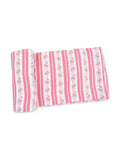 Pink and white striped fabric with floral patterns, rolled up on one side.