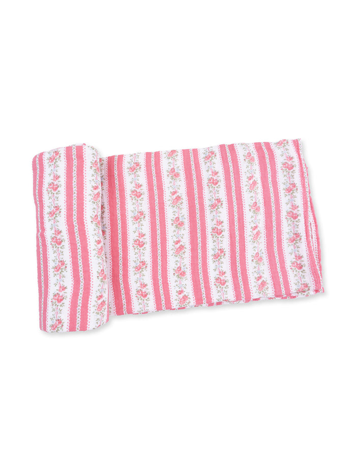 Pink and white striped fabric with floral patterns, rolled up on one side.
