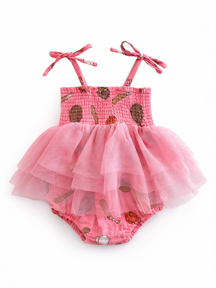 Light pink baby dress with tulle layers and playful food prints, featuring adjustable straps. Perfect for warm weather.