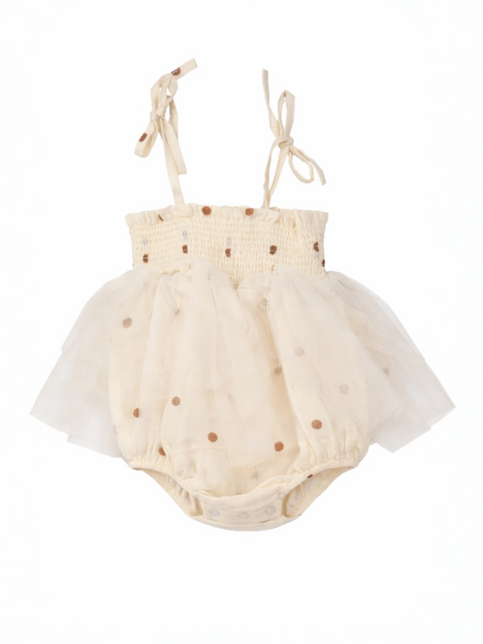 Cream-colored baby dress with polka dots and tulle skirt, featuring adjustable straps for a snug fit.