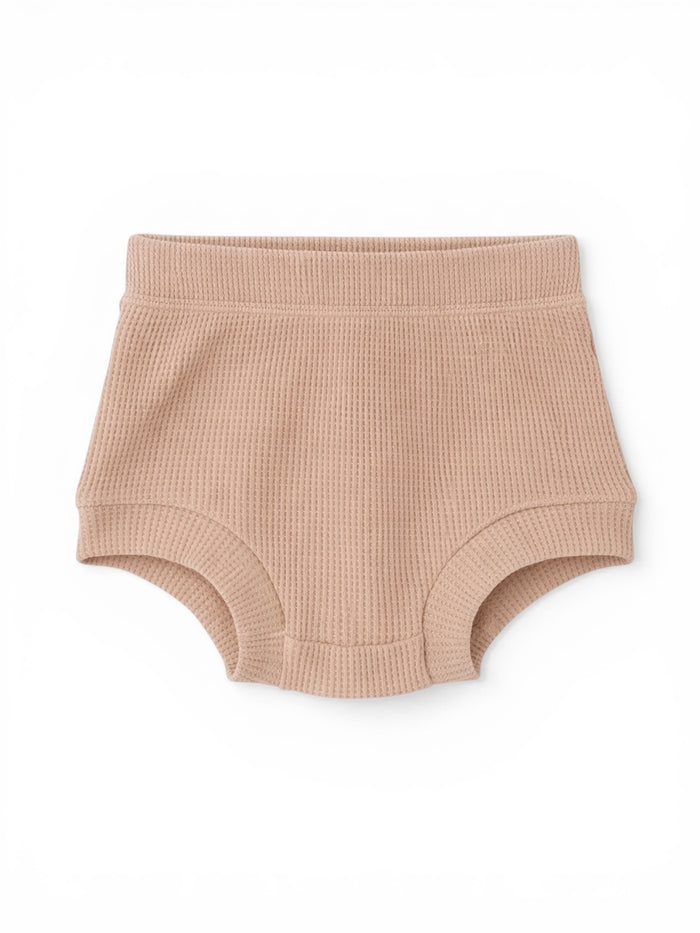 Light pink ribbed baby shorts with a comfortable waistband, designed for warmth and ease of movement.