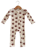 Children's one-piece pajama with brown paw print pattern, hung on a wooden hanger against a neutral background.