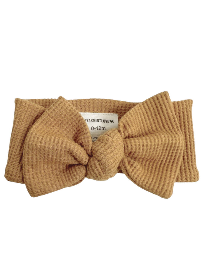 Tan baby headband with a knot, suitable for infants 0-12 months, by Spearmint Love.