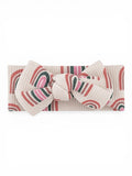 Beige headband with colorful rainbow patterns and a large bow at the center.
