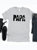 Gray t-shirt with "PAPA" design, featuring fishing graphics, styled with black sneakers and denim jeans.
