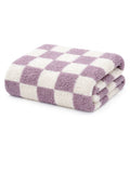 Folded checkered towel in soft purple and white fabric, ideal for bathrooms or spa settings.