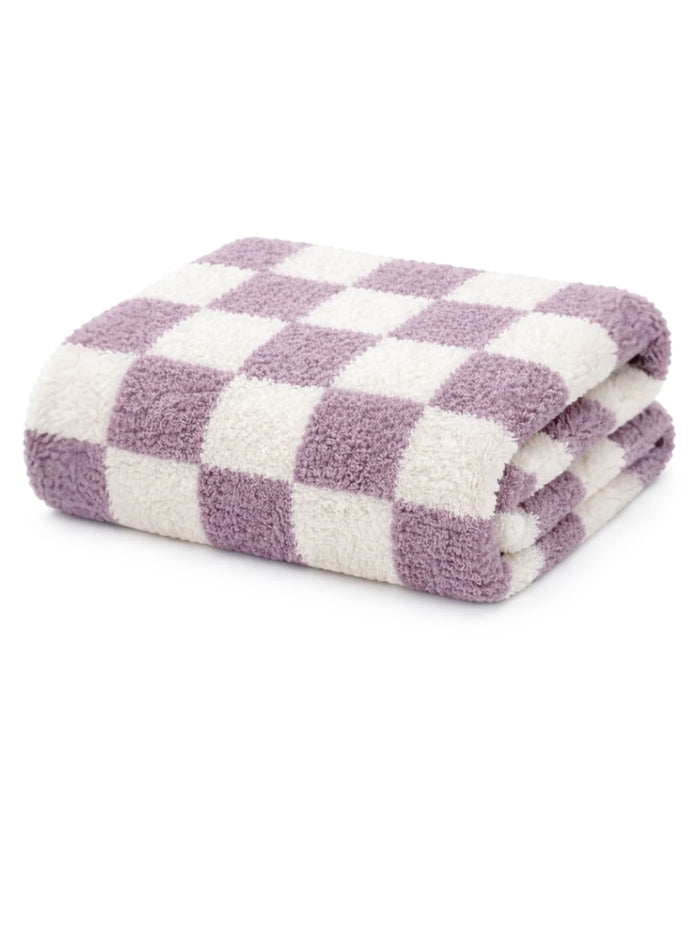 Folded checkered towel in soft purple and white fabric, ideal for bathrooms or spa settings.