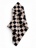 Black and beige checkered towel folded diagonally on a white background.