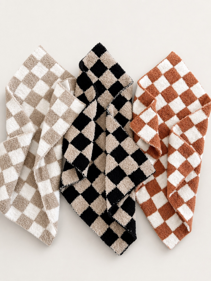 Checkered towels in beige, black, and rust colors displayed on a light background.