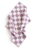 Purple and white checkered fabric draped on a flat surface, showcasing its soft texture and pattern.