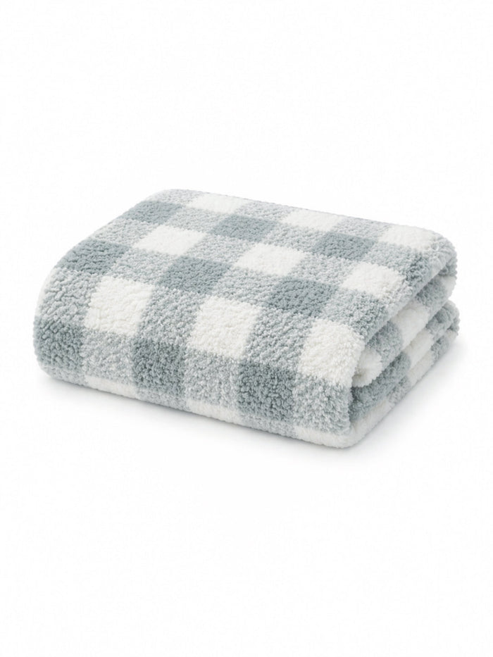 Soft, folded blanket with a blue and white checkered pattern on a white background.