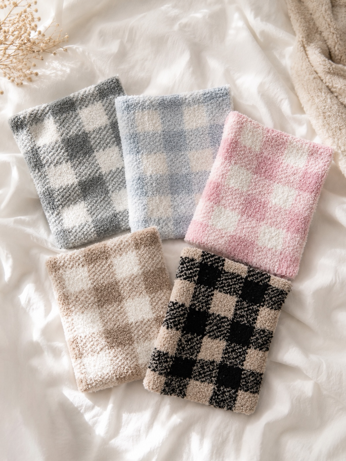 Five soft, checkered fabric swatches in various colors arranged on a light, textured background.