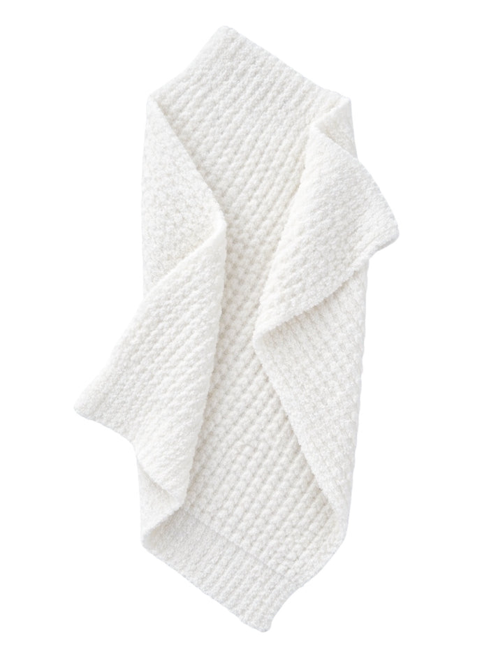 Textured white blanket draped elegantly, showcasing its cozy and soft appearance.