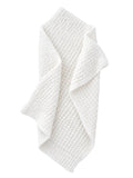 Textured white blanket draped elegantly, showcasing its cozy and soft appearance.