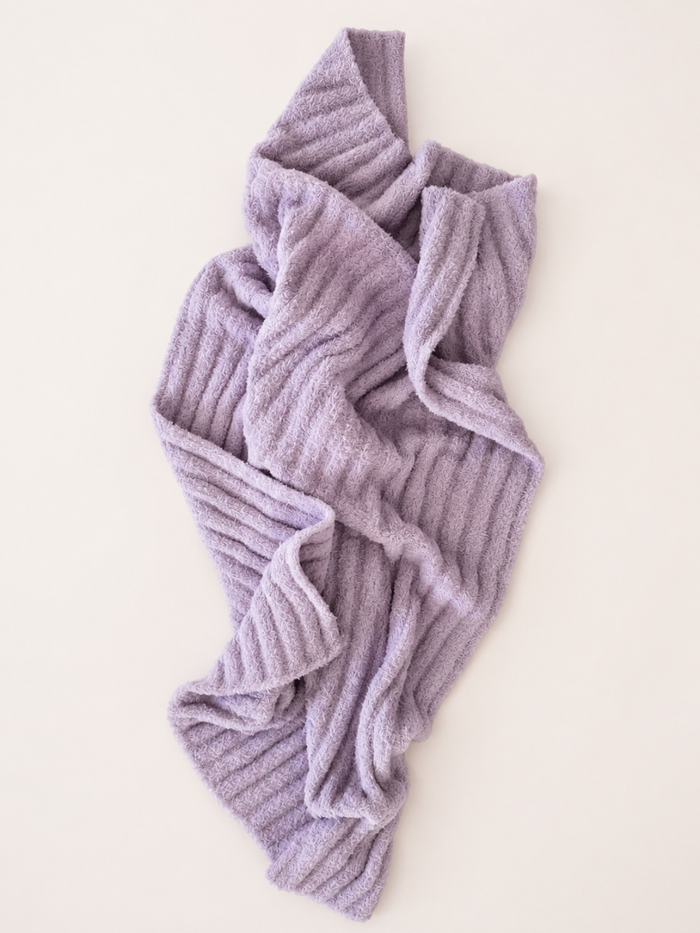 Lavender textured blanket draped on a light background, showcasing cozy design and softness.