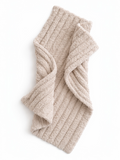 Beige ribbed scarf laid flat, showcasing its soft texture and folded design against a white background.