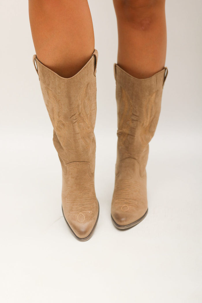 Tan knee-high boots on a white background