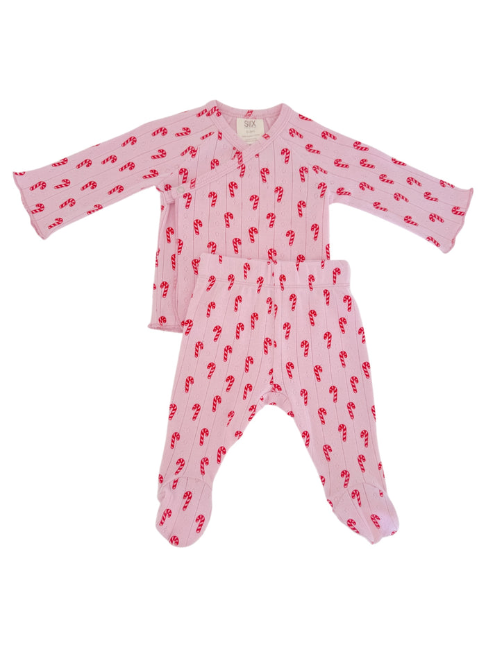 Baby pajama set with long sleeves and pants, featuring a pink color and red candy cane pattern.
