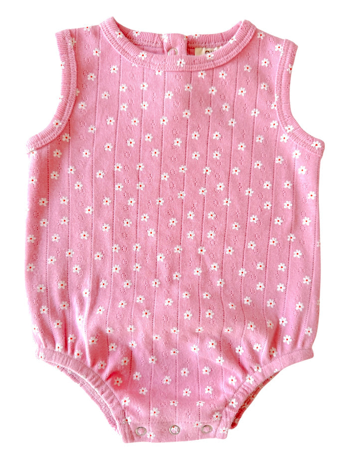 Pink sleeveless baby onesie with white floral pattern and snap closures at the bottom.