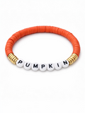 Orange beaded bracelet with white letter beads spelling "PUMPKIN" and gold accents.