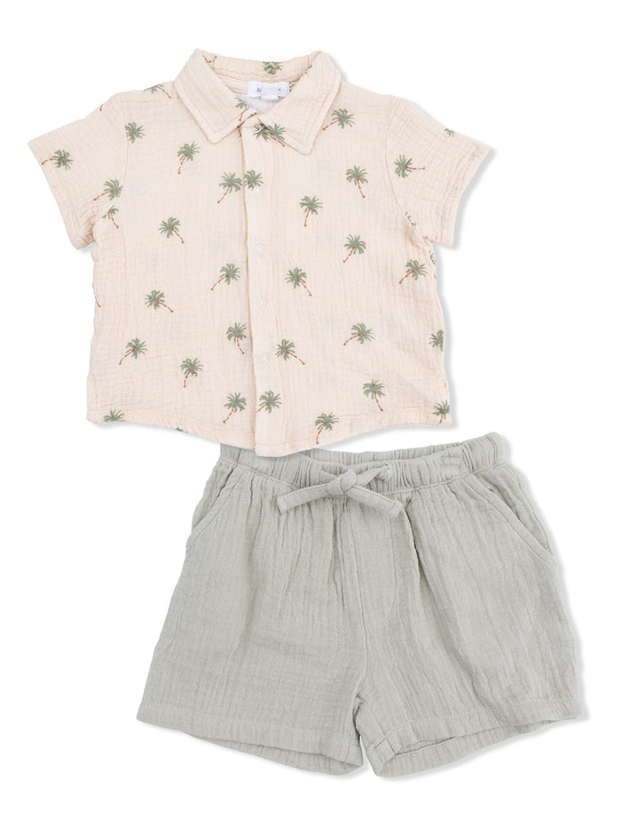 Light pink short-sleeve shirt with palm tree print paired with gray shorts with drawstring.