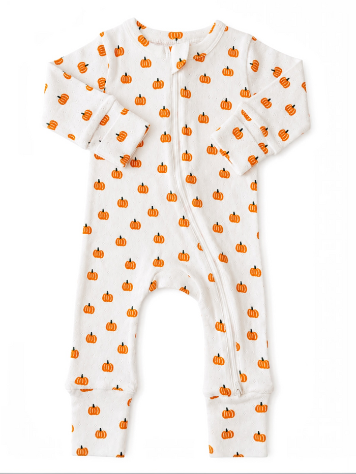 White pajama onesie with orange pumpkin prints, featuring long sleeves and a front zipper closure.