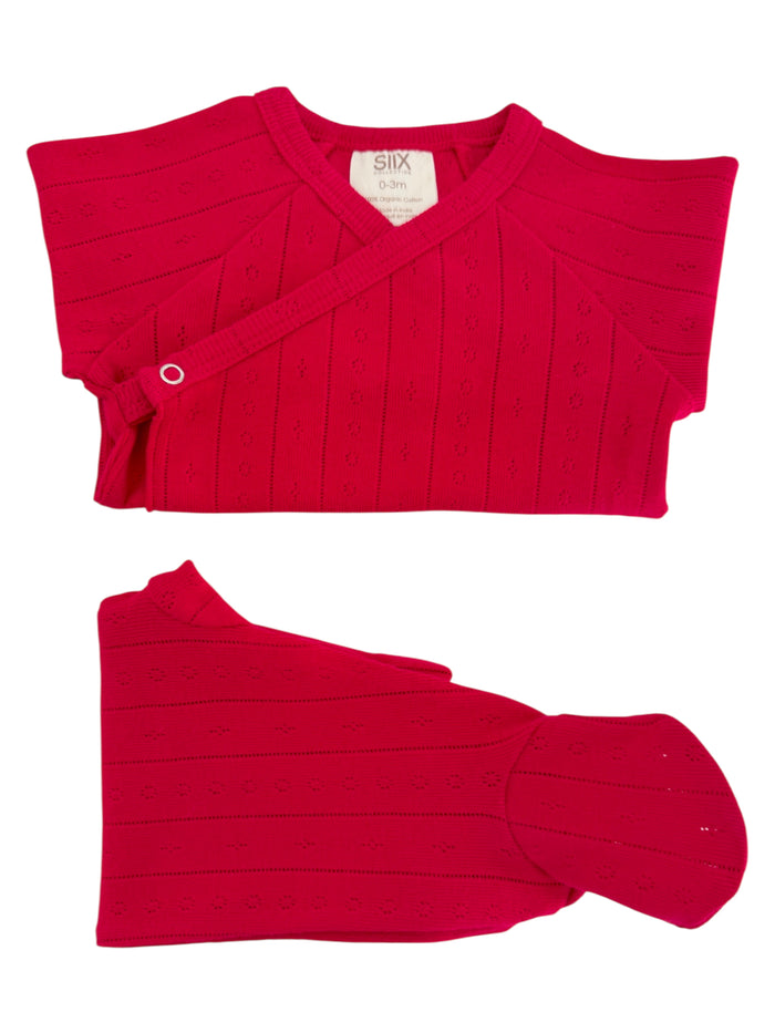 Bright red, organic cotton infant outfit with a cross-body design and flower patterns, suitable for ages 0-3 months.