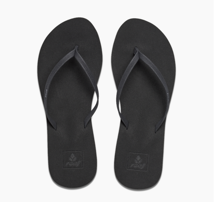 A pair of black Reef Bliss Nights flip flops with PVC free vegan leather straps and a soft foam footbed.