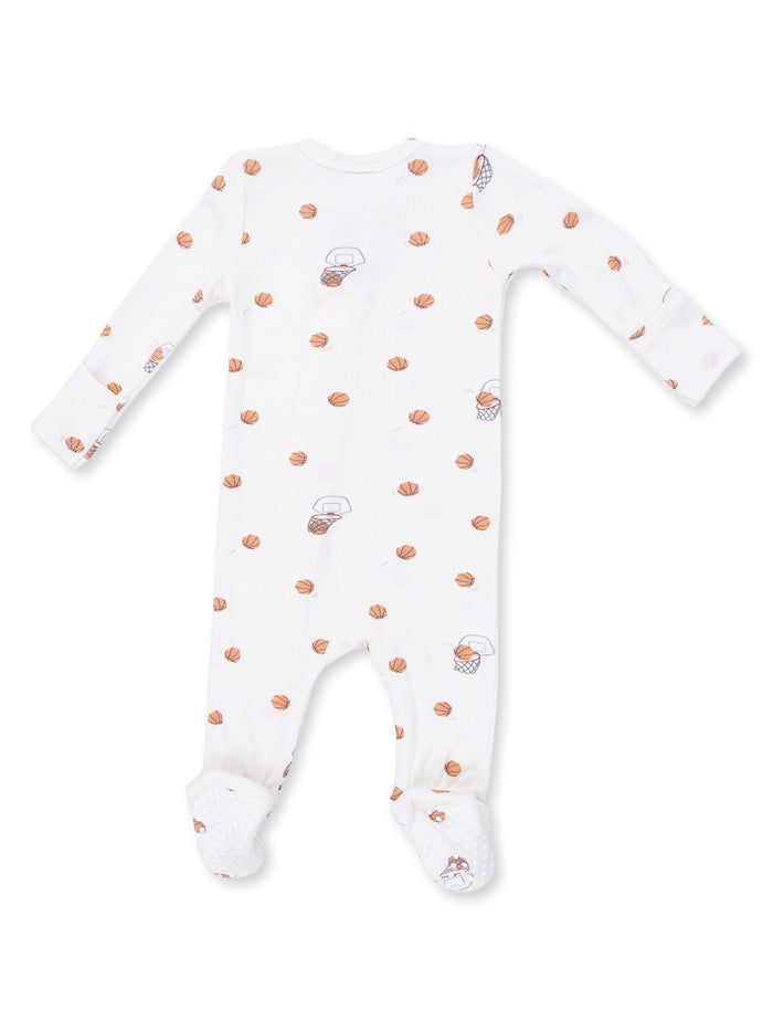 White infant footed pajamas with basketball print and rubber grips on the feet.