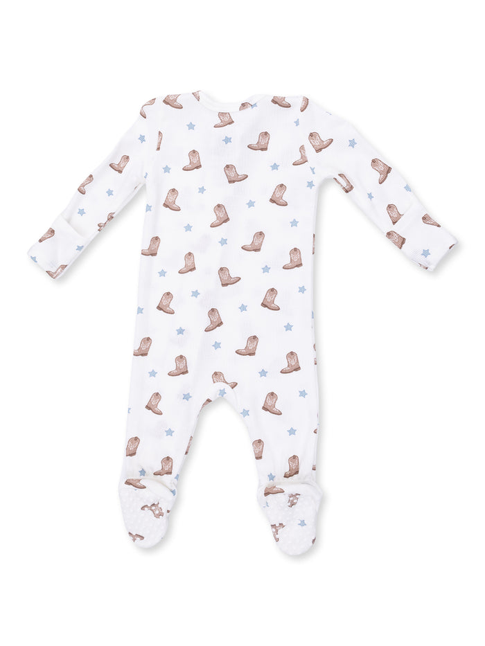 White baby onesie featuring a cowboy boot and star pattern, with footed legs and long sleeves.
